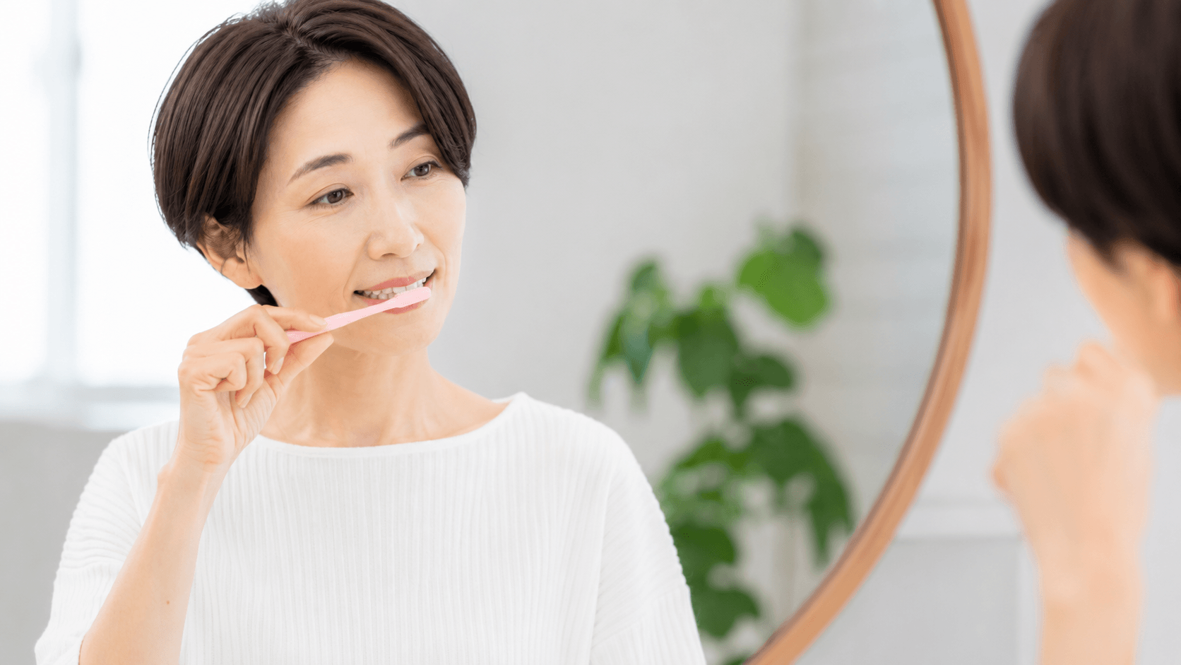 インプラントを長持ちさせるために歯磨きをする女性